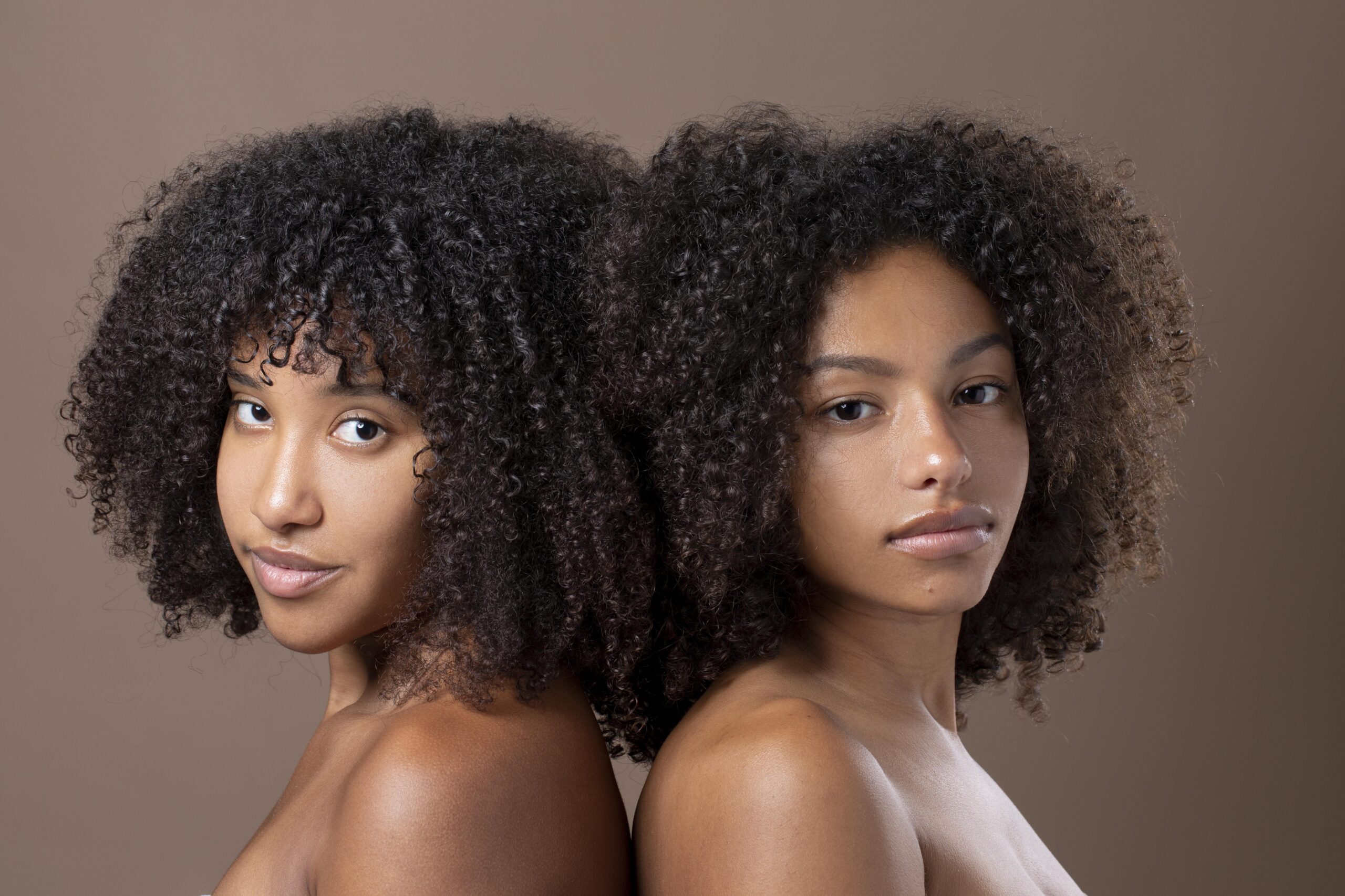 two-beautiful-black-women-posing-together with curly wigs